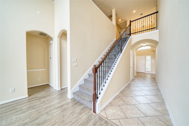 24618 Malca Manor Dr, Katy, TX 77493 - stairs with arched walkways, visible vents, baseboards, and a towering ceiling
