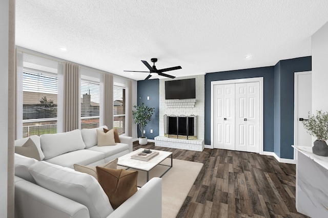 living room with dark wood-style flooring, a textured ceiling, ceiling fan, and baseboards