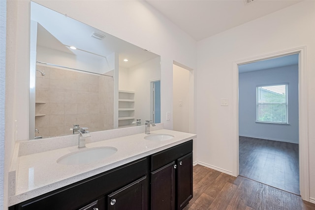 12518 Pelican Bay Dr, Houston, TX 77038 - bathroom with double vanity, a sink, wood finished floors, and a shower
