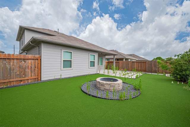 12518 Pelican Bay Dr, Houston, TX 77038 - back of property with a fenced backyard, a lawn, and an outdoor fire pit
