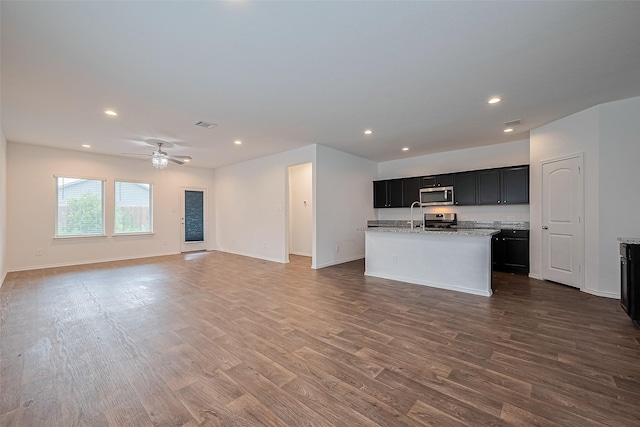 12518 Pelican Bay Dr, Houston, TX 77038 - kitchen with dark cabinets, appliances with stainless steel finishes, wood finished floors, and open floor plan