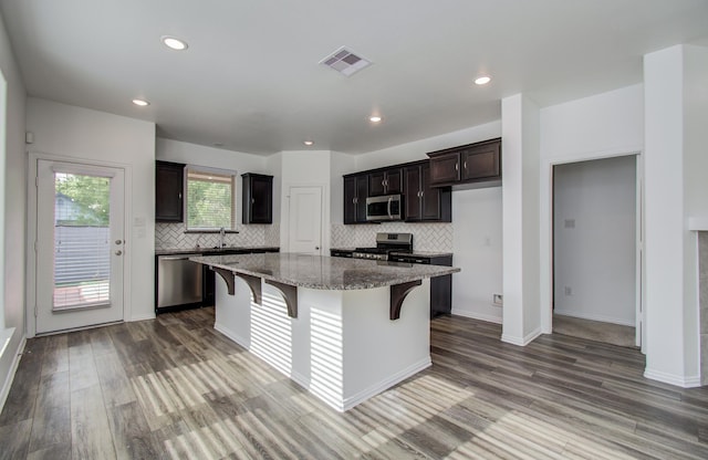 kitchen featuring visible vents, decorative backsplash, dark wood finished floors, and appliances with stainless steel finishes