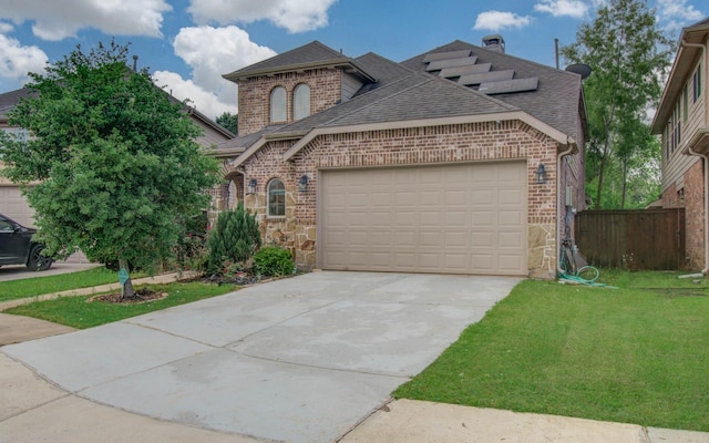 french country home featuring roof with shingles, brick siding, a front lawn, and a garage