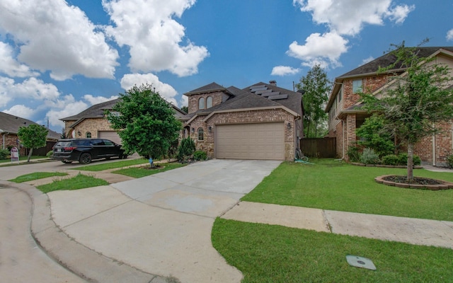 view of front of property with a front lawn, fence, brick siding, an attached garage, and driveway