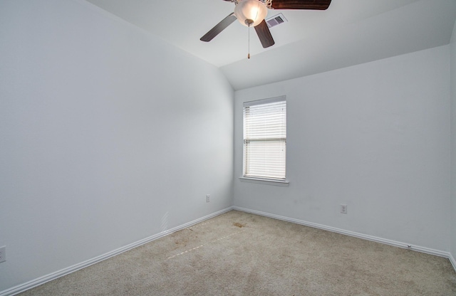 unfurnished room with a ceiling fan, visible vents, baseboards, lofted ceiling, and light carpet