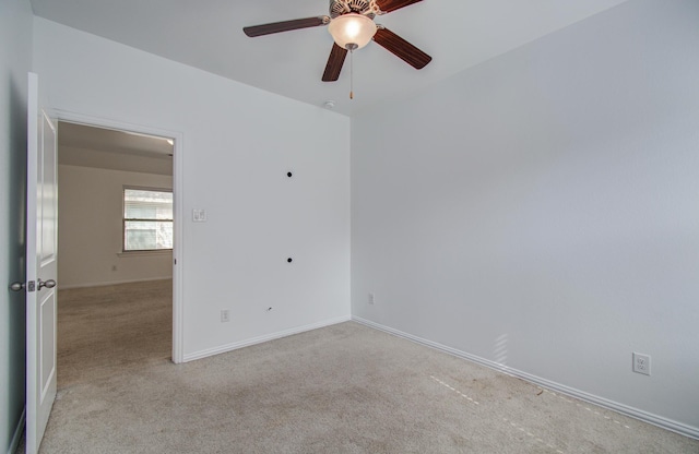 empty room featuring baseboards, ceiling fan, and carpet flooring