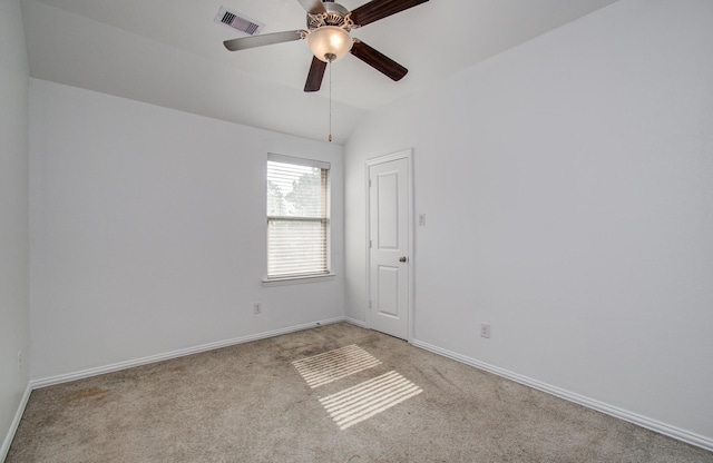 unfurnished room with light colored carpet, a ceiling fan, baseboards, vaulted ceiling, and visible vents