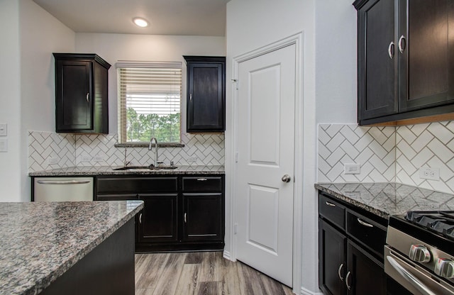 3730 Bach St, Iowa Colony, TX 77583 - kitchen featuring stainless steel appliances, dark stone countertops, tasteful backsplash, and light wood finished floors