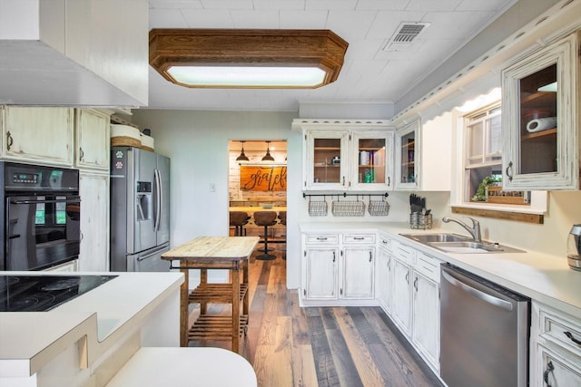 307 N St, Baytown, TX 77520 - kitchen with dark wood-style flooring, visible vents, light countertops, a sink, and black appliances