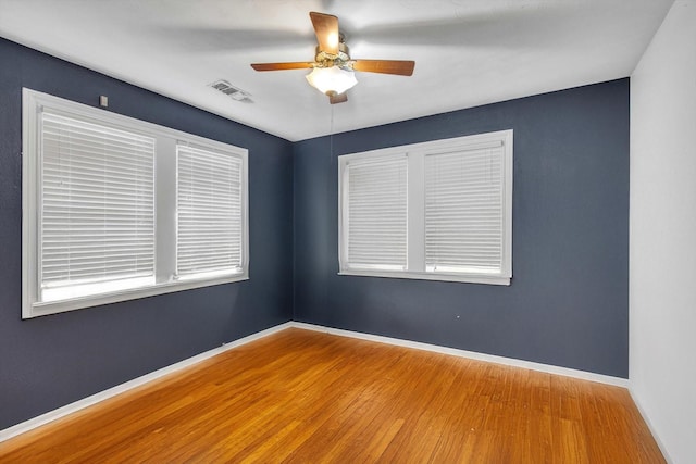 307 N St, Baytown, TX 77520 - unfurnished room with baseboards, ceiling fan, wood finished floors, and visible vents