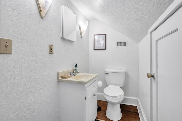 307 N St, Baytown, TX 77520 - bathroom featuring a textured ceiling, visible vents, wood finished floors, toilet, and lofted ceiling