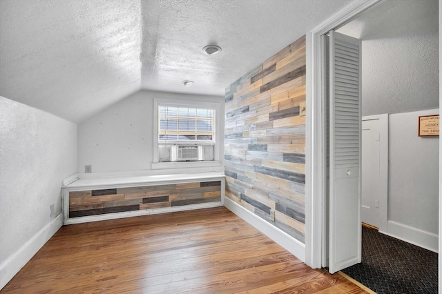 307 N St, Baytown, TX 77520 - bonus room with a textured ceiling, wood finished floors, baseboards, lofted ceiling, and wooden walls