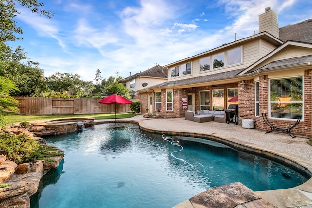 view of swimming pool featuring a patio, a pool with connected hot tub, outdoor lounge area, and a fenced backyard