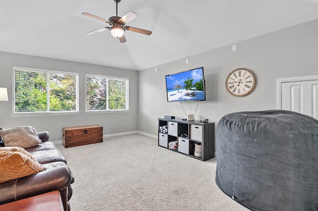 living area with carpet flooring, a ceiling fan, baseboards, and lofted ceiling