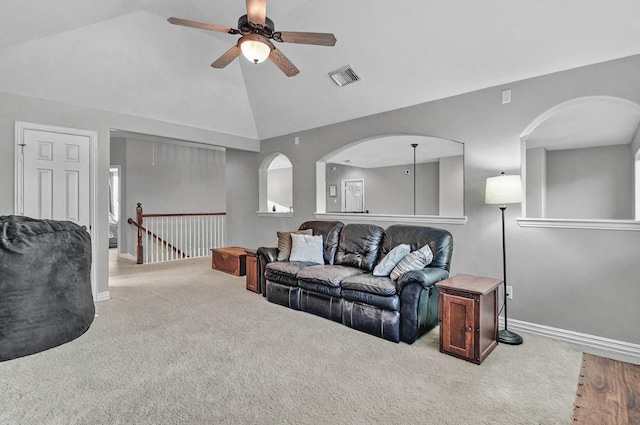 living room with carpet flooring, ceiling fan, visible vents, and vaulted ceiling