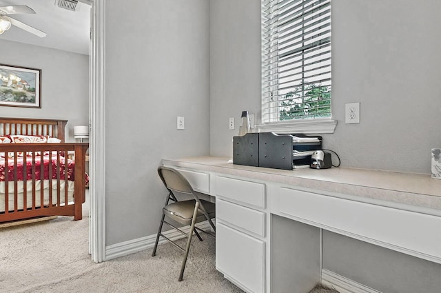 home office featuring light colored carpet, a ceiling fan, baseboards, and visible vents