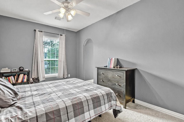 bedroom featuring visible vents, carpet flooring, baseboards, ceiling fan, and arched walkways