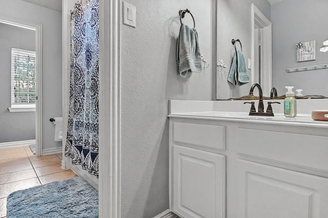 bathroom with vanity, baseboards, tile patterned floors, and a shower with curtain