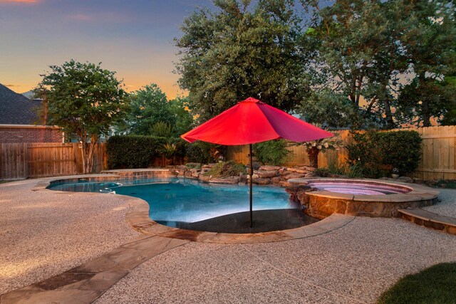 view of pool featuring a patio, a pool with connected hot tub, and a fenced backyard
