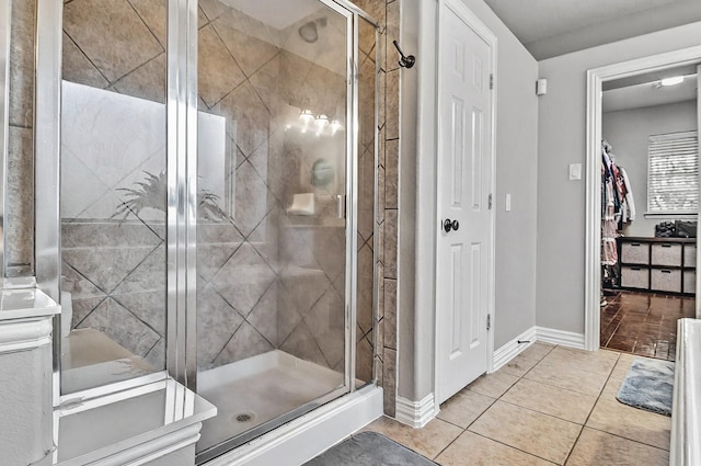 full bath with baseboards, a stall shower, and tile patterned floors