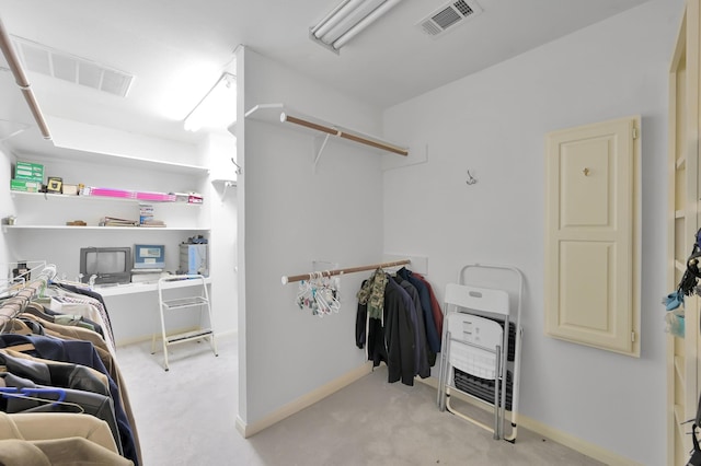 walk in closet with visible vents and light colored carpet