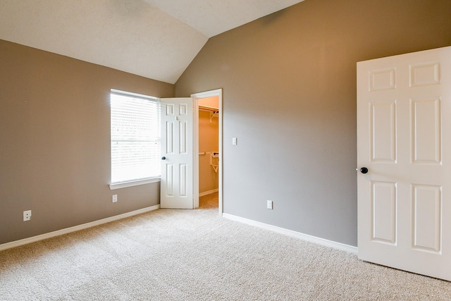 241 Blue Hill Dr, Montgomery, TX 77356 - unfurnished bedroom featuring a closet, lofted ceiling, baseboards, a spacious closet, and carpet flooring