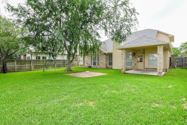 241 Blue Hill Dr, Montgomery, TX 77356 - rear view of property featuring a fenced backyard, roof with shingles, brick siding, a patio area, and a lawn
