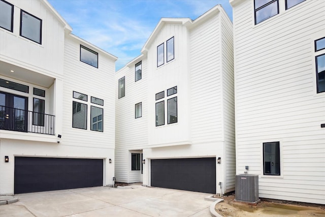 exterior space featuring an attached garage, driveway, and central AC unit