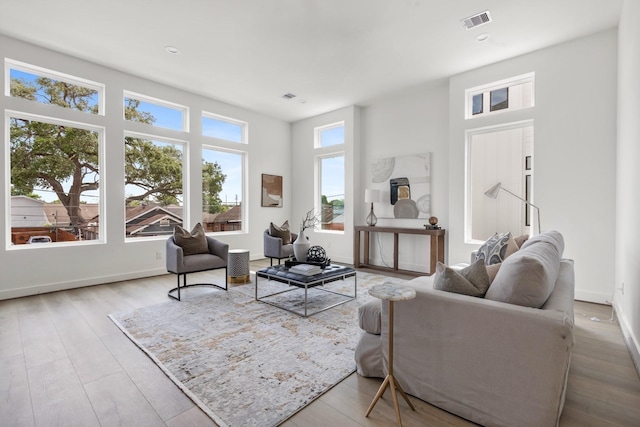 living room with visible vents, baseboards, and wood finished floors
