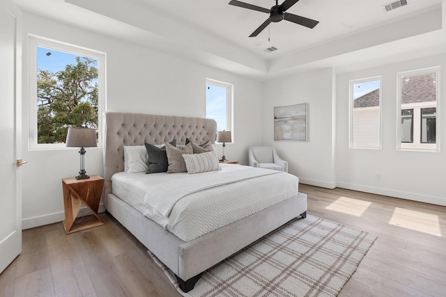bedroom with baseboards, light wood-style flooring, and visible vents