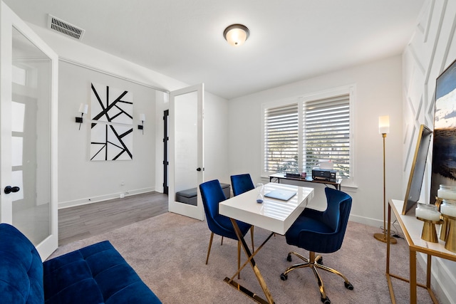 office featuring carpet flooring, baseboards, and visible vents