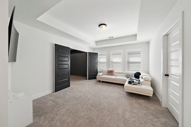 sitting room with a raised ceiling, baseboards, carpet flooring, and visible vents