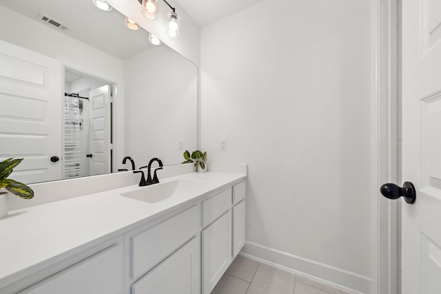 bathroom with visible vents, baseboards, tile patterned floors, and vanity