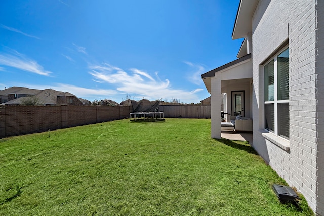 view of yard with a fenced backyard and a trampoline