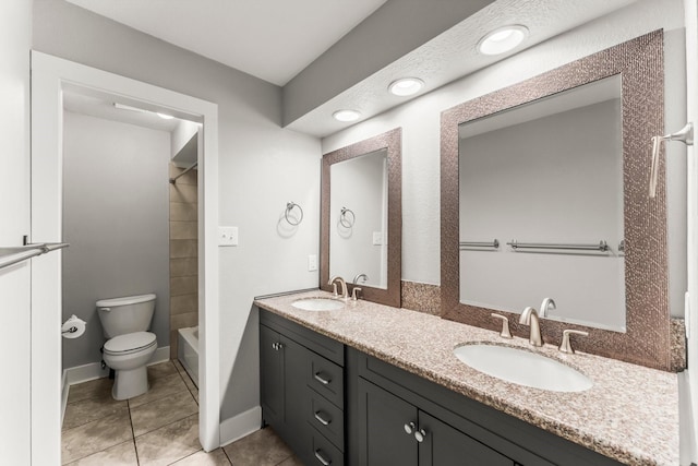 full bath with double vanity, toilet, tile patterned floors, and a sink