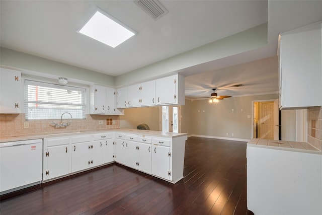 kitchen with white dishwasher, visible vents, a sink, and tasteful backsplash