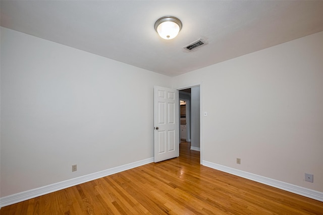 spare room with baseboards, visible vents, and light wood-style flooring