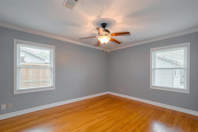 spare room with baseboards, visible vents, ornamental molding, and light wood finished floors