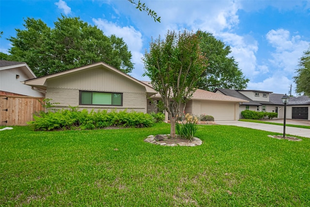 ranch-style home with an attached garage, fence, a front yard, and concrete driveway