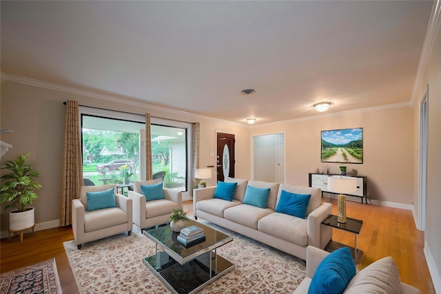 living room featuring crown molding, baseboards, and wood finished floors