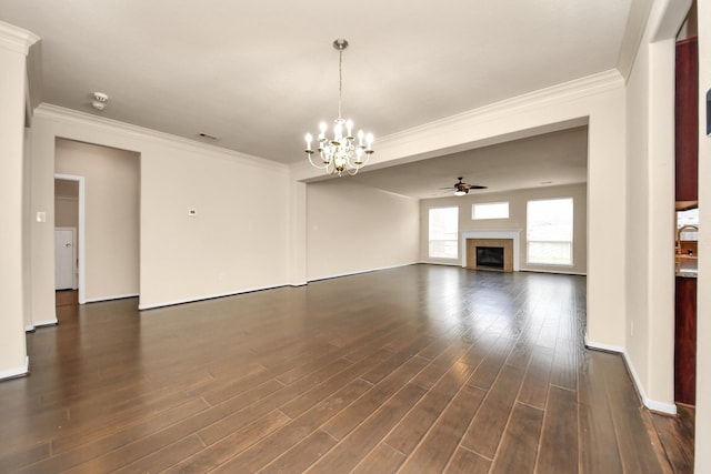 unfurnished living room with dark wood-style flooring, a glass covered fireplace, ornamental molding, and ceiling fan with notable chandelier