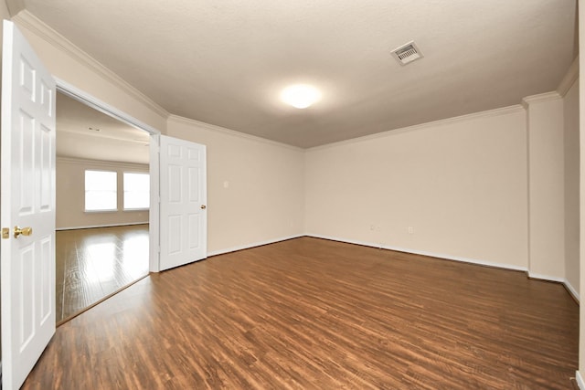 unfurnished room with baseboards, visible vents, ornamental molding, and dark wood-type flooring