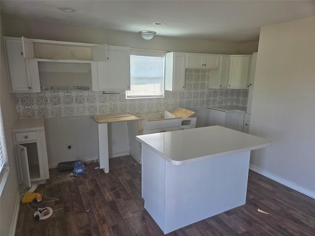 kitchen with baseboards, dark wood-style floors, a center island, white cabinets, and backsplash