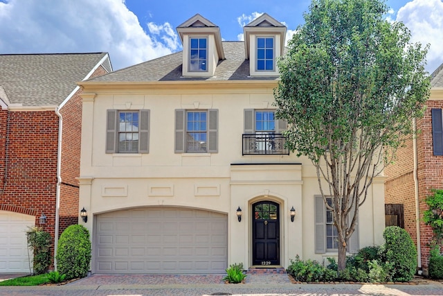 view of front of home with a garage, a shingled roof, stucco siding, and driveway
