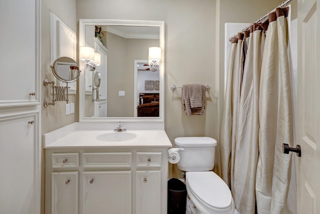 bathroom with vanity, ornamental molding, and toilet