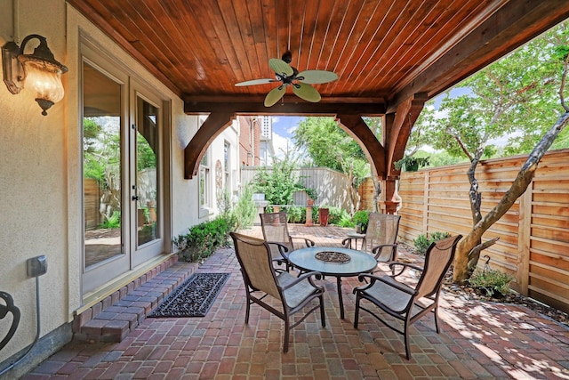 view of patio / terrace featuring a fenced backyard, ceiling fan, and a fire pit