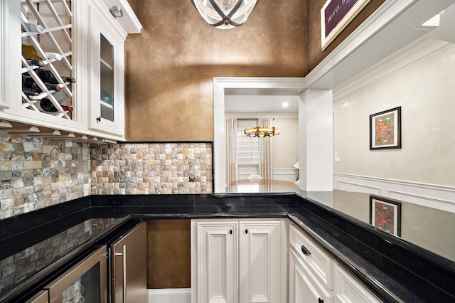 bar featuring decorative backsplash, indoor wet bar, and a chandelier