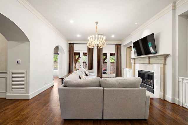 living area featuring arched walkways, ornamental molding, dark wood finished floors, and visible vents