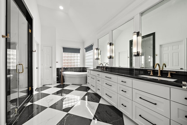 bathroom with double vanity, a freestanding tub, a shower stall, and a sink