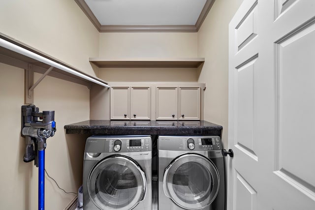 laundry room with ornamental molding, cabinet space, and washing machine and clothes dryer